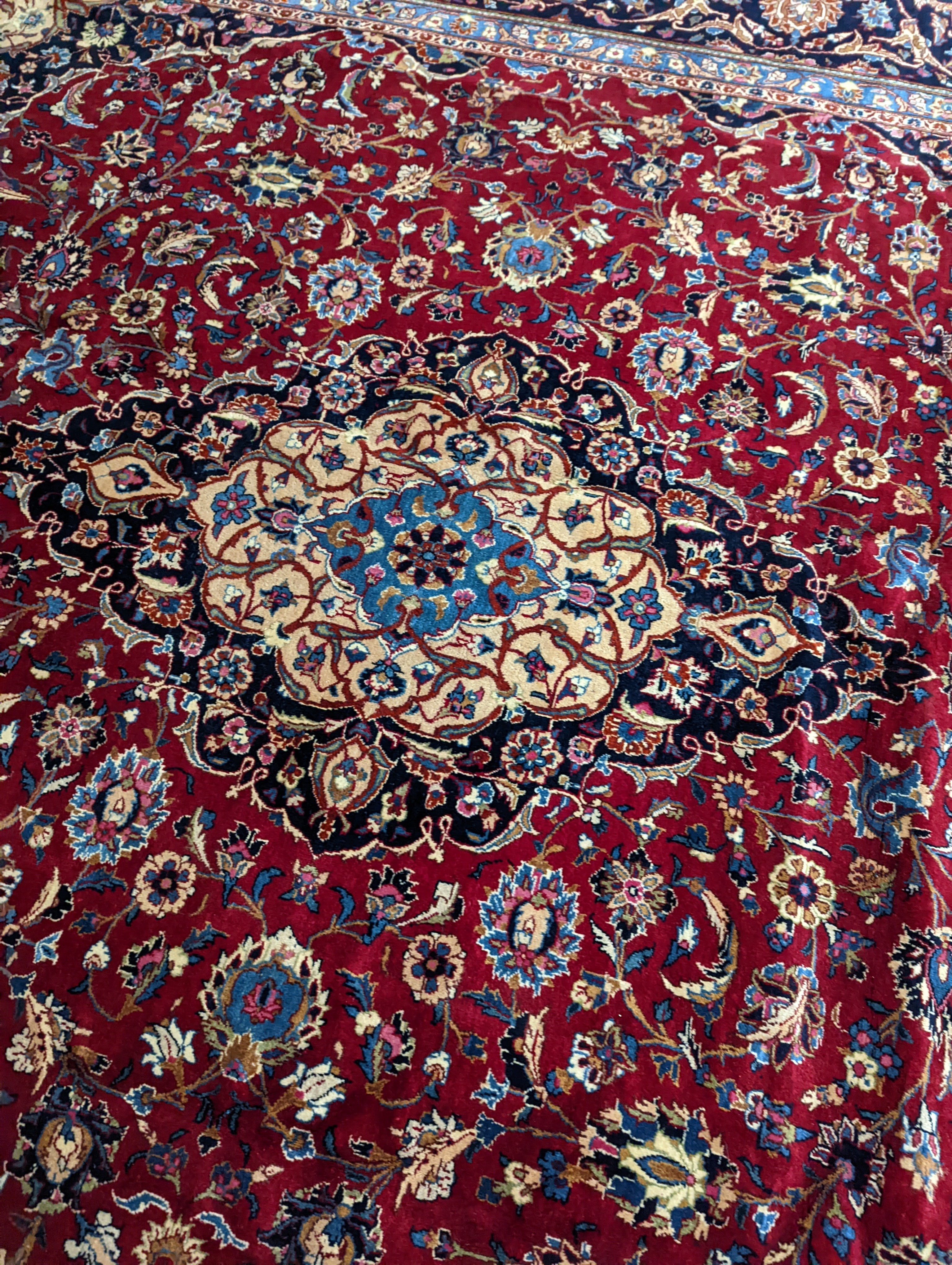 A Kashan burgundy ground carpet, 380 x 300cm